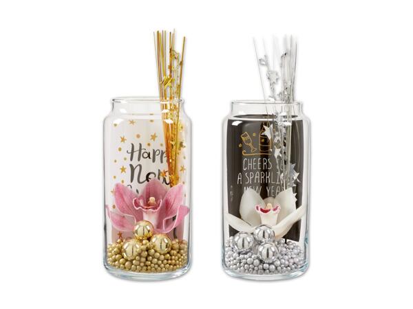 Orchideenblüte mit Silvesterdekoration im Glas