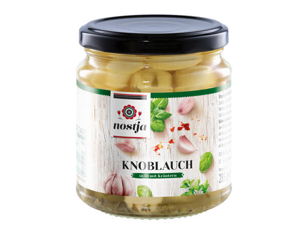 Ganze Knoblauchzehen in Öl mit Kräutern